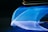A dynamic display of flowing blue light streaks against a dark background, creating a sense of motion and speed. The lights form abstract patterns with lines and curves, offering a futuristic and vibrant aesthetic.