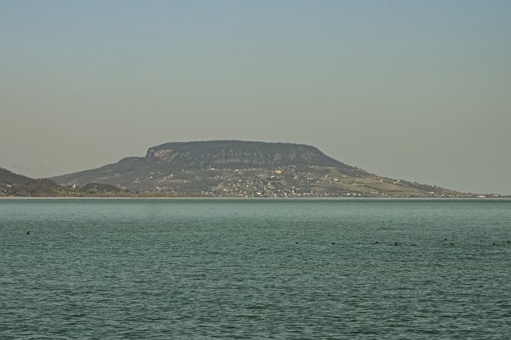 a large body of water with a mountain in the background