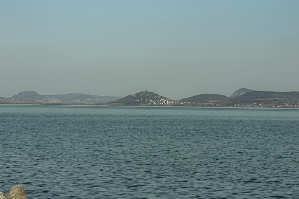 a large body of water with mountains in the background