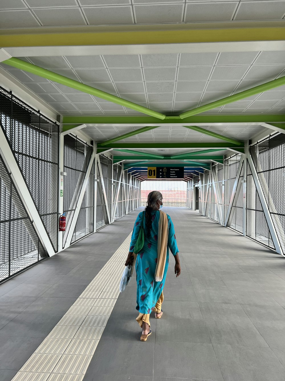 a woman in a blue outfit walking down a walkway