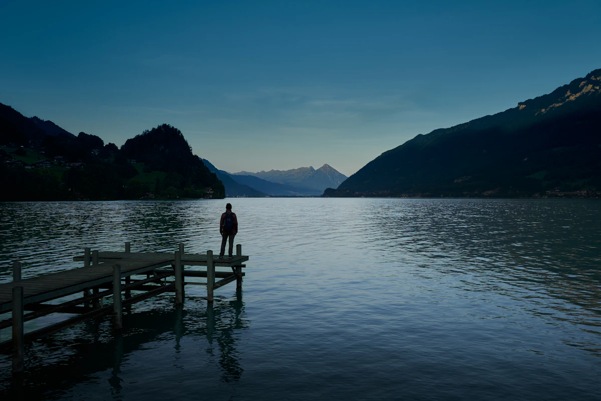 A figure on a jetty on a Bernese Oberland lake at dusk