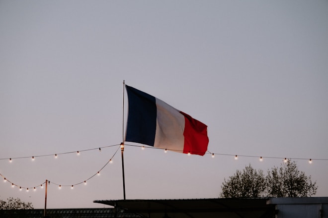 a flag flying in the air with string lights around it