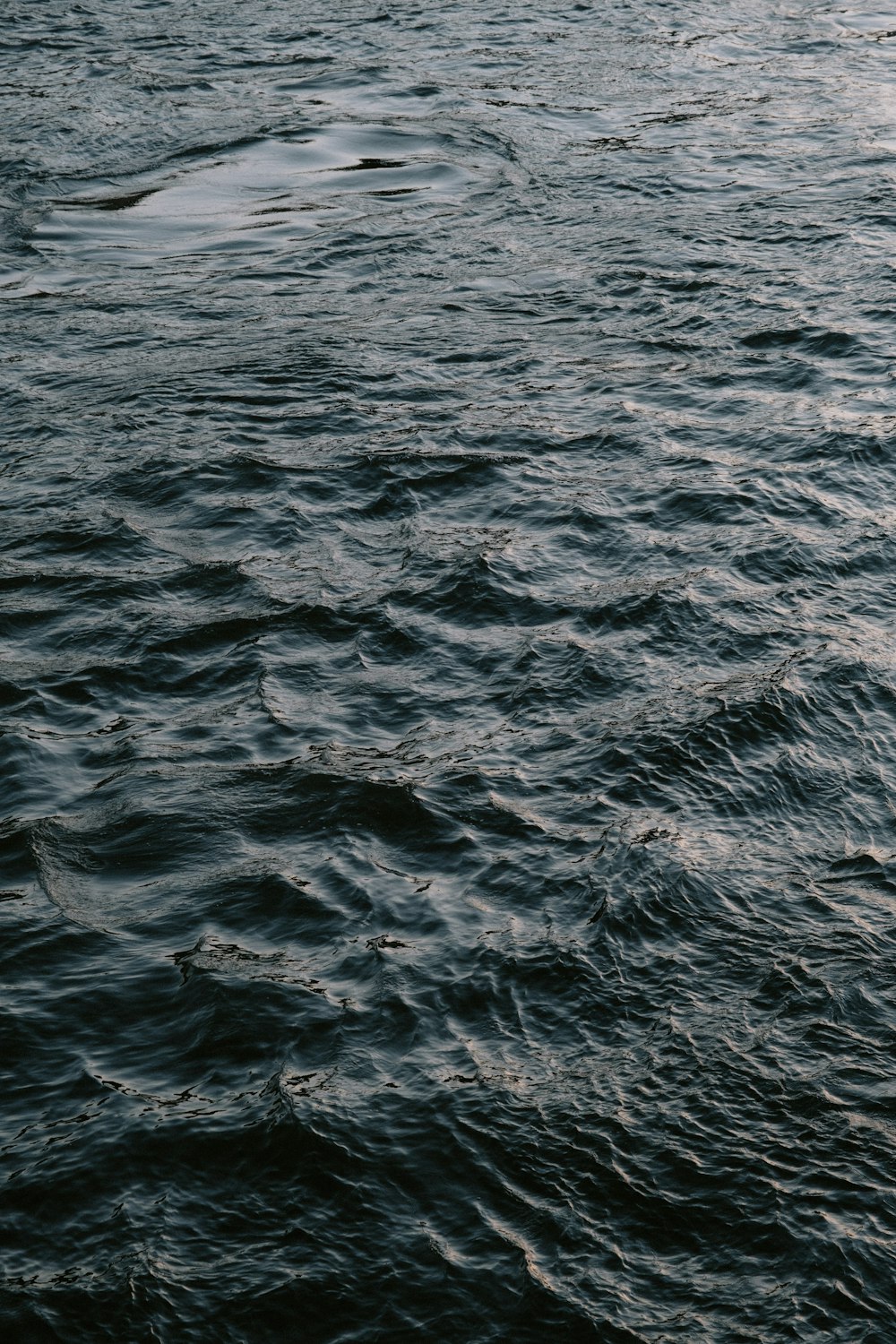 a large body of water with a boat in the distance