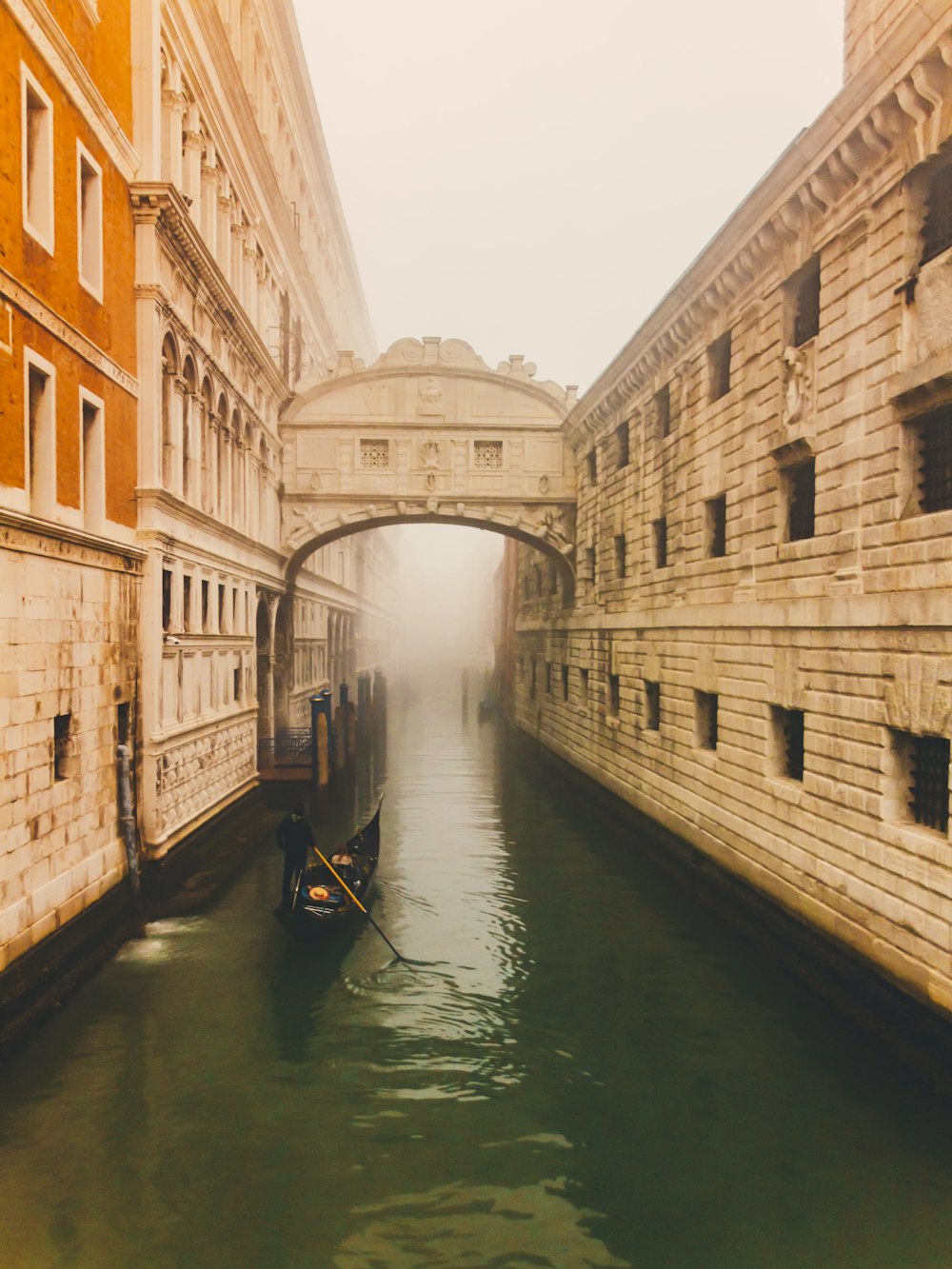 a narrow canal with a bridge in the background