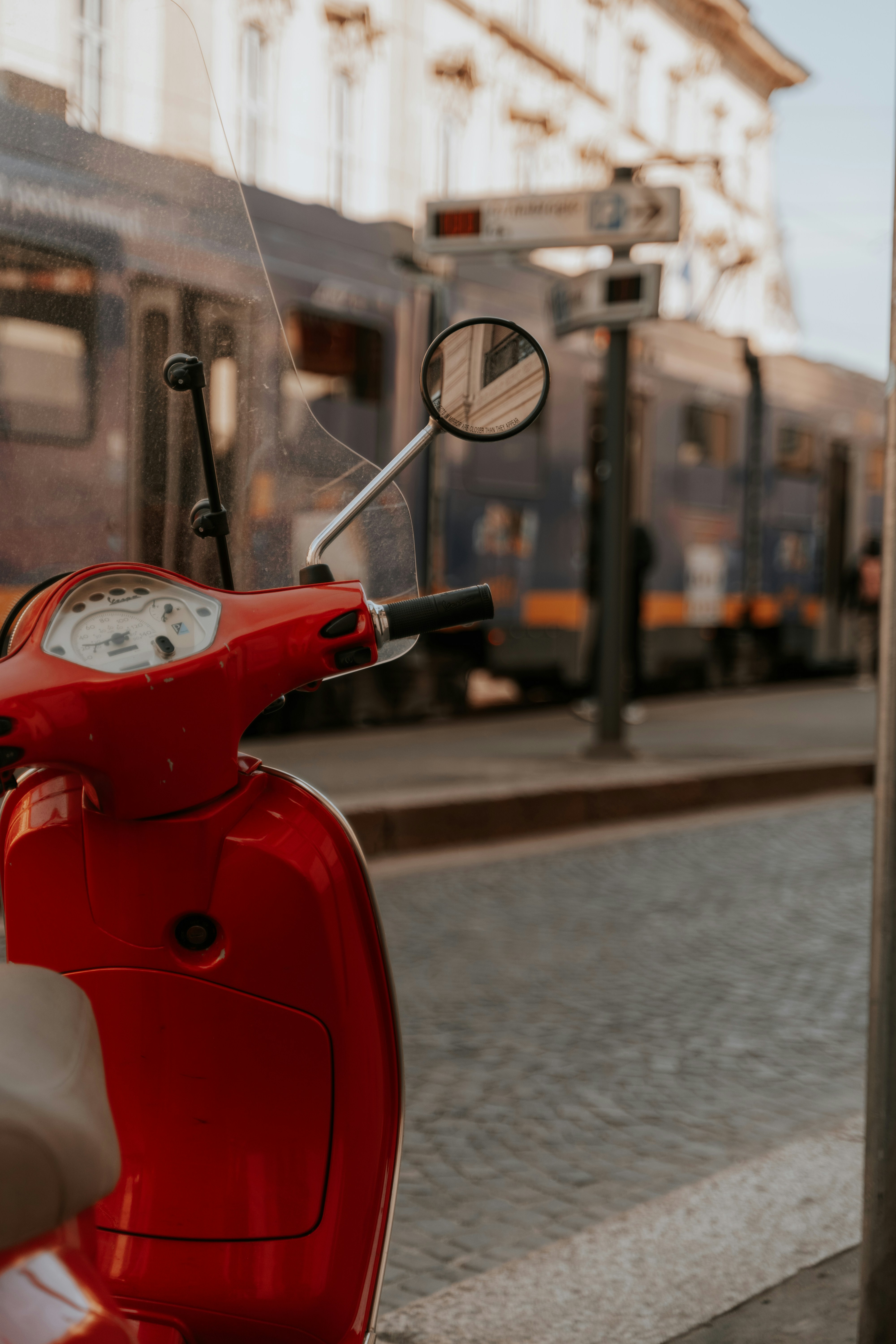 uma scooter vermelha estacionada na beira da estrada