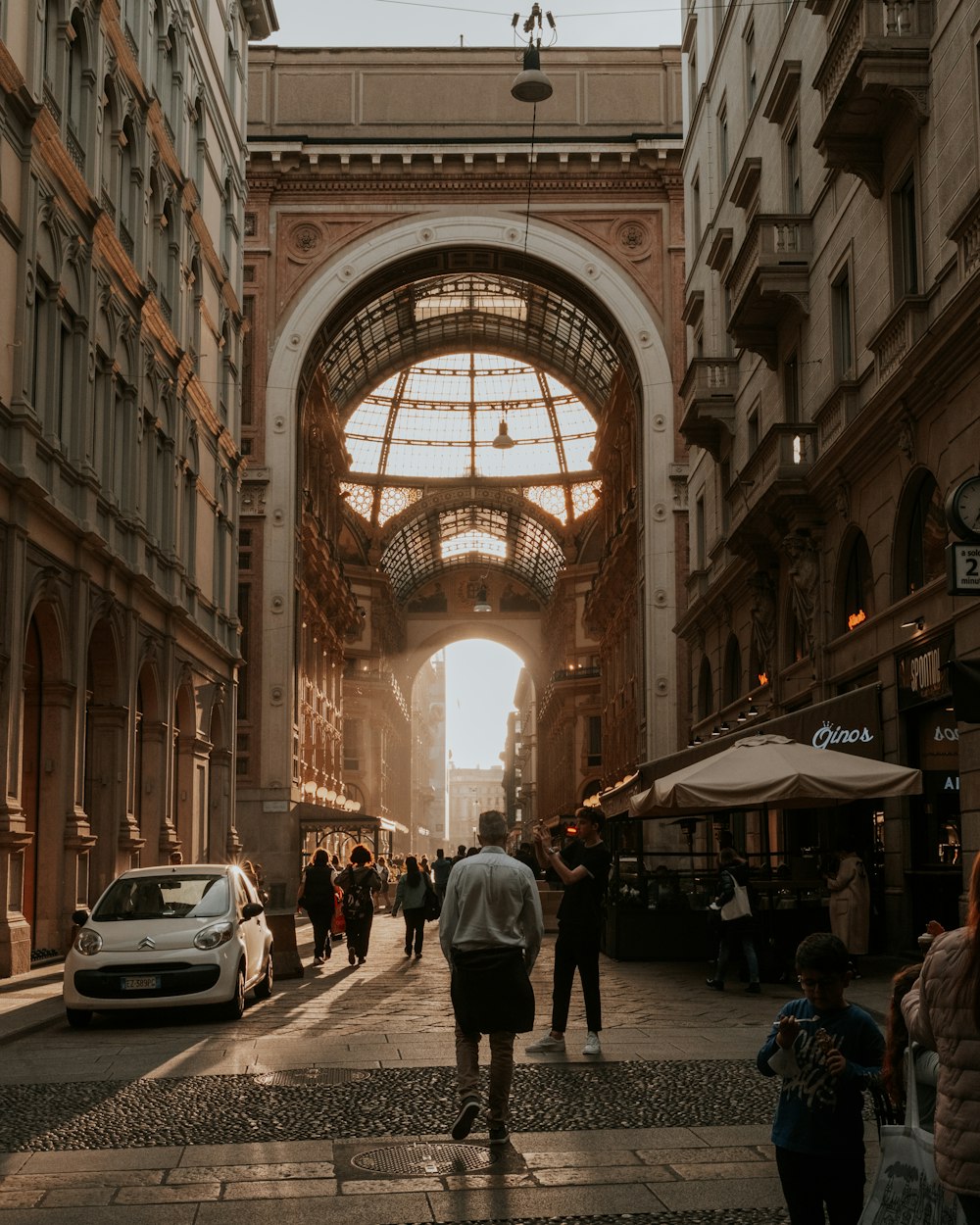 Un gruppo di persone che camminano lungo una strada accanto a edifici alti