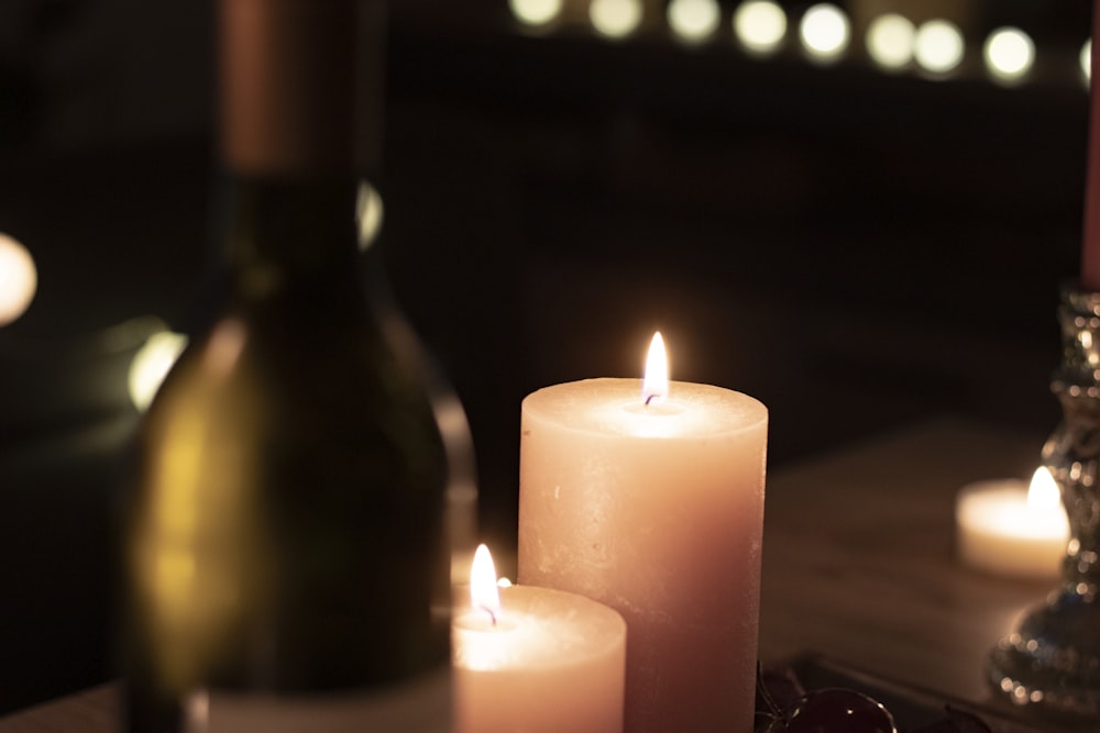 a bottle of wine and two candles on a table