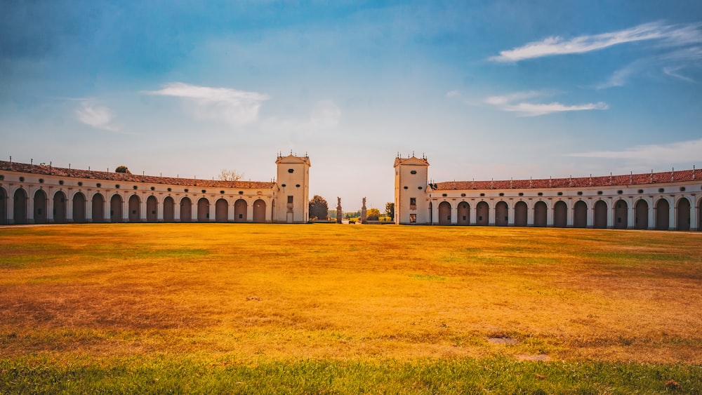 a large building with arches and grass in front of it