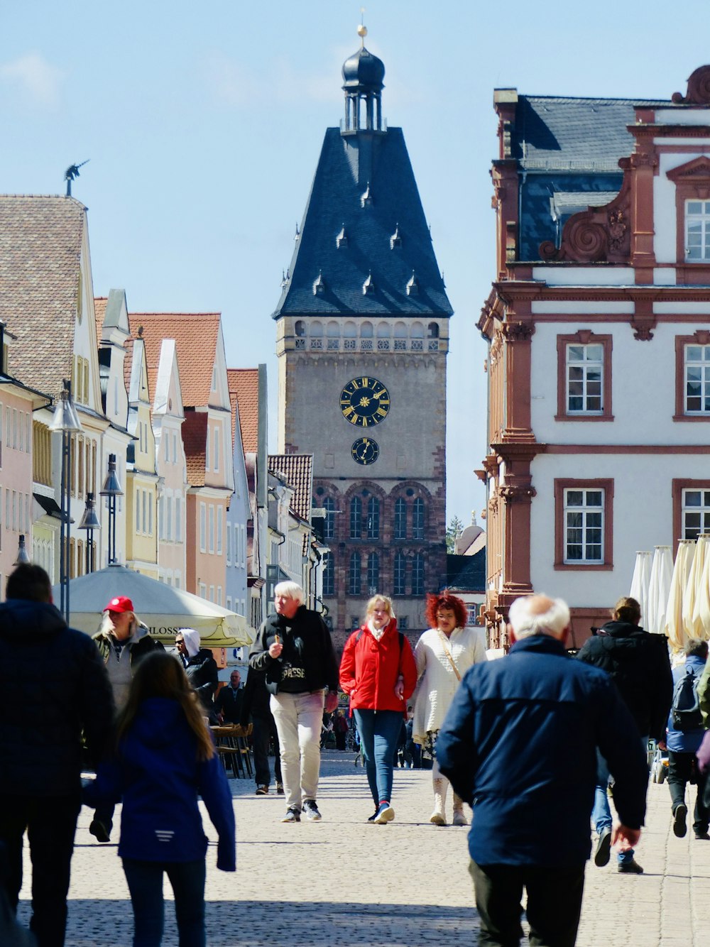 a crowd of people walking down a street next to tall buildings