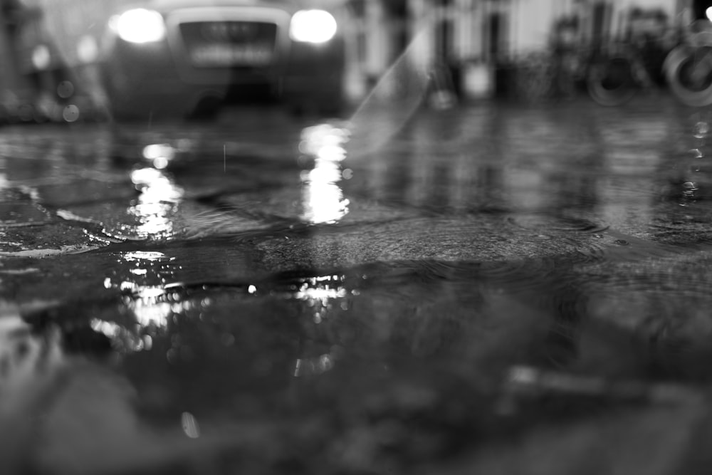 Une photo en noir et blanc d’une rue pluvieuse