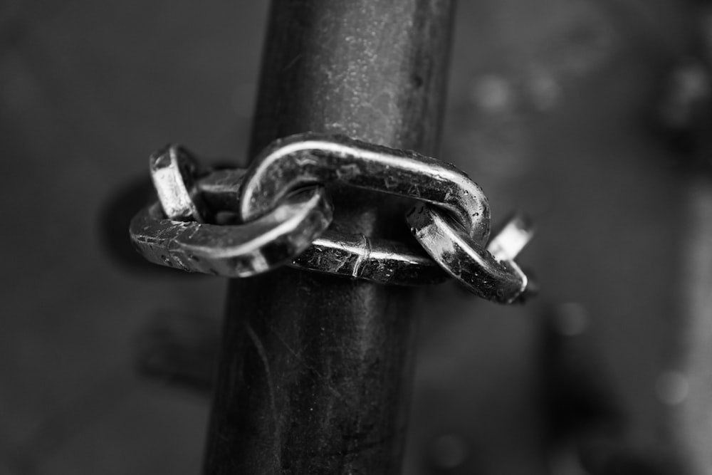 a black and white photo of a chain on a pole