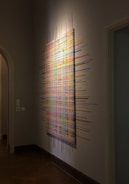 An abstract artwork displayed in a modern gallery.