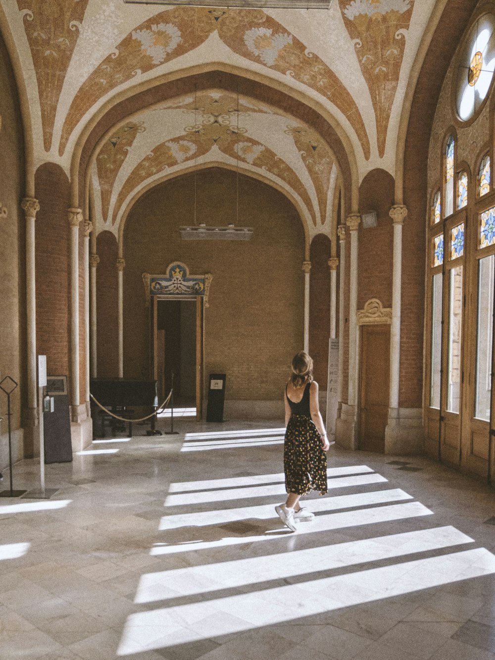 a woman in a long dress walking through a building