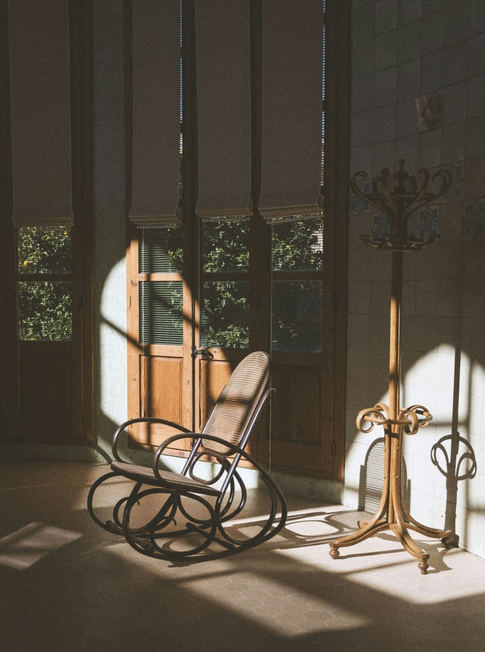a rocking chair sitting in a room next to a window