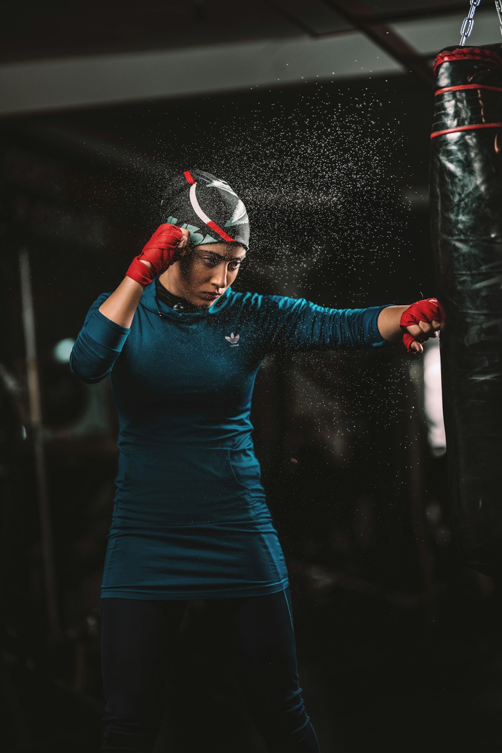 Una mujer con guantes de boxeo está golpeando un saco de boxeo