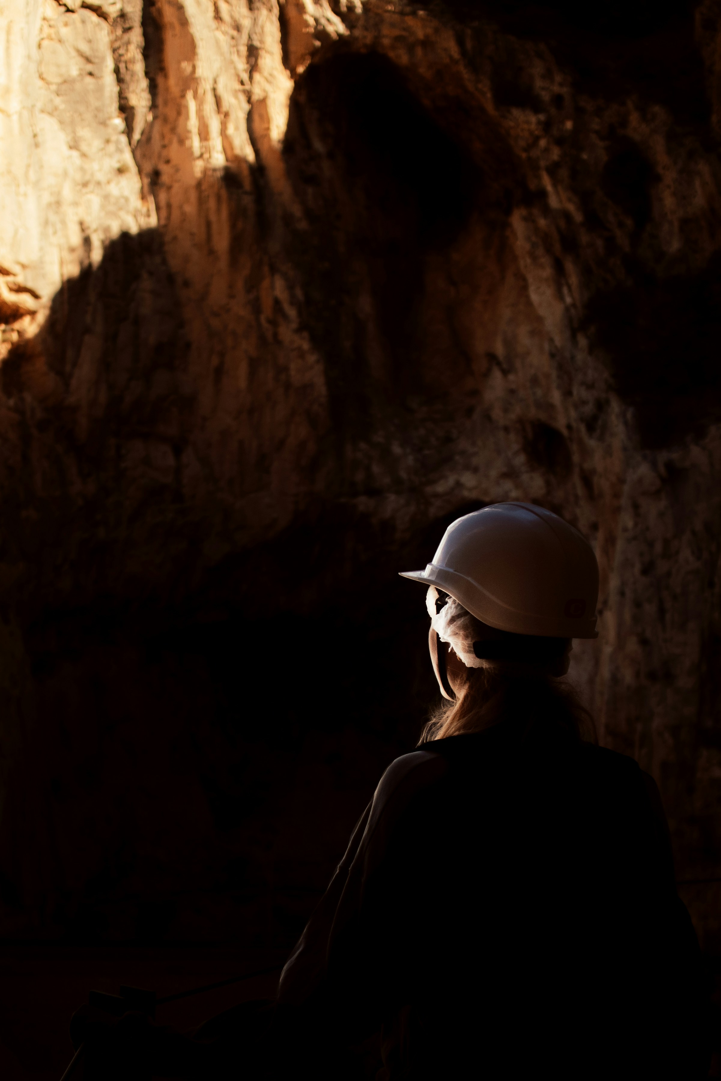 une personne portant un casque debout dans une grotte