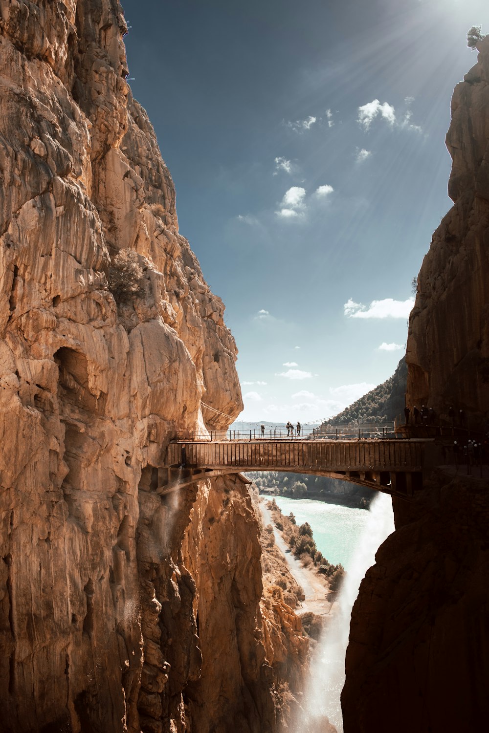 a bridge over a body of water near a mountain