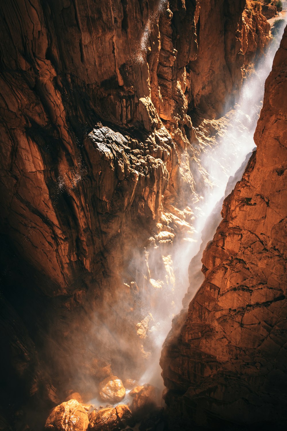 a waterfall flowing into a canyon surrounded by rocks