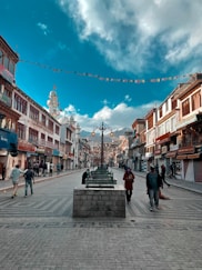 a group of people walking down a street next to tall buildings