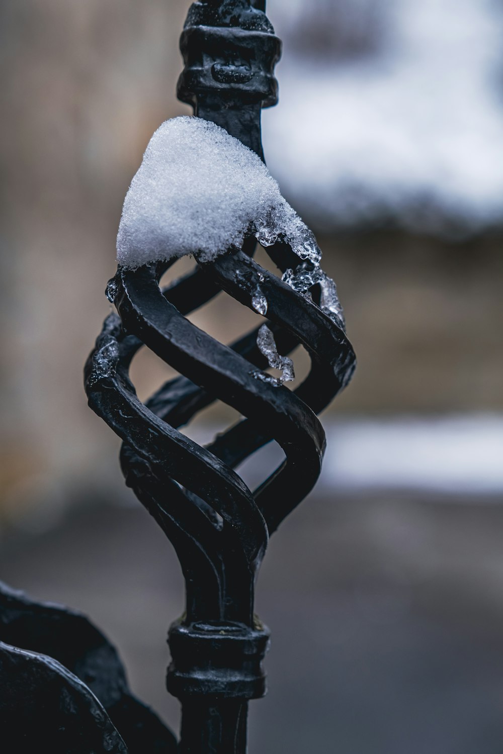 a wrought iron fence with snow on top of it