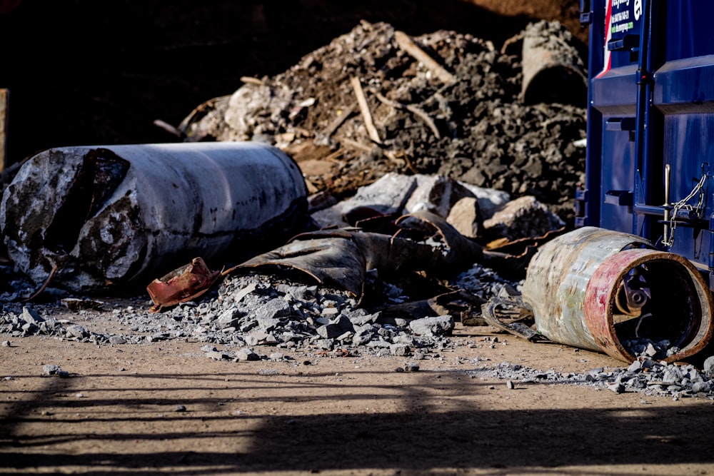 a pile of rubble next to a blue dumpster