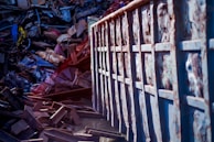 a pile of junk next to a metal fence container metalle