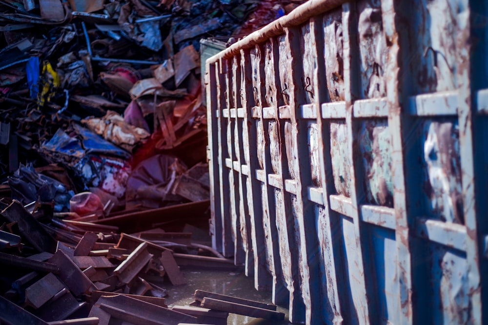 a pile of junk next to a metal fence