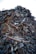 A large heap of assorted scrap metal and debris, including rusted pipes, wires, metal sheets, and various other discarded items, forming a significant pile. The background is a clear sky.