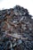 A large heap of assorted scrap metal and debris, including rusted pipes, wires, metal sheets, and various other discarded items, forming a significant pile. The background is a clear sky.