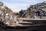 a pile of scrap metal sitting on top of a dirt field