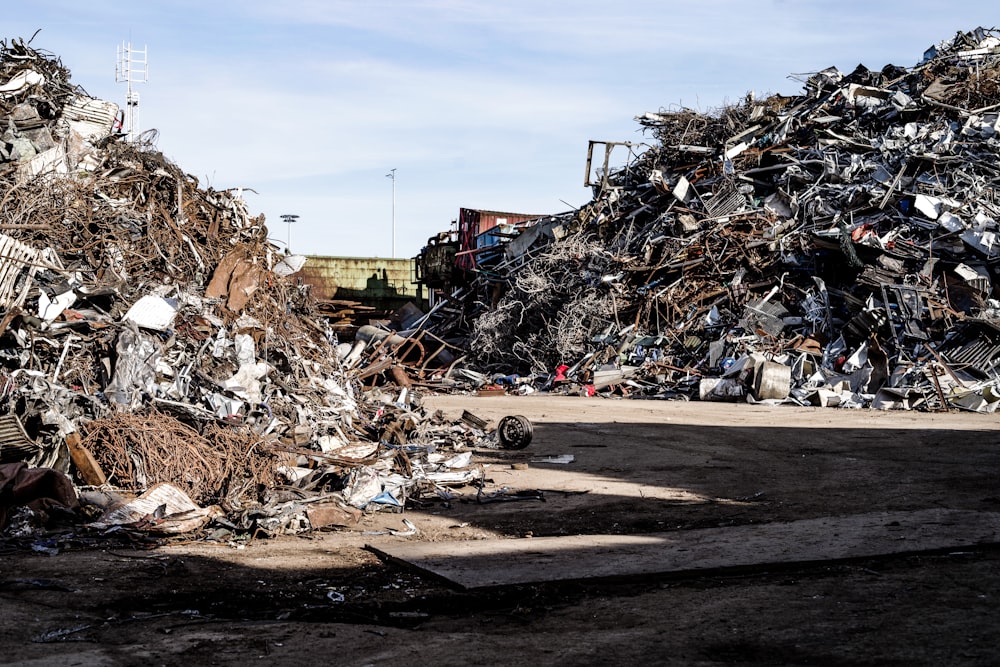 a pile of scrap metal sitting on top of a dirt field