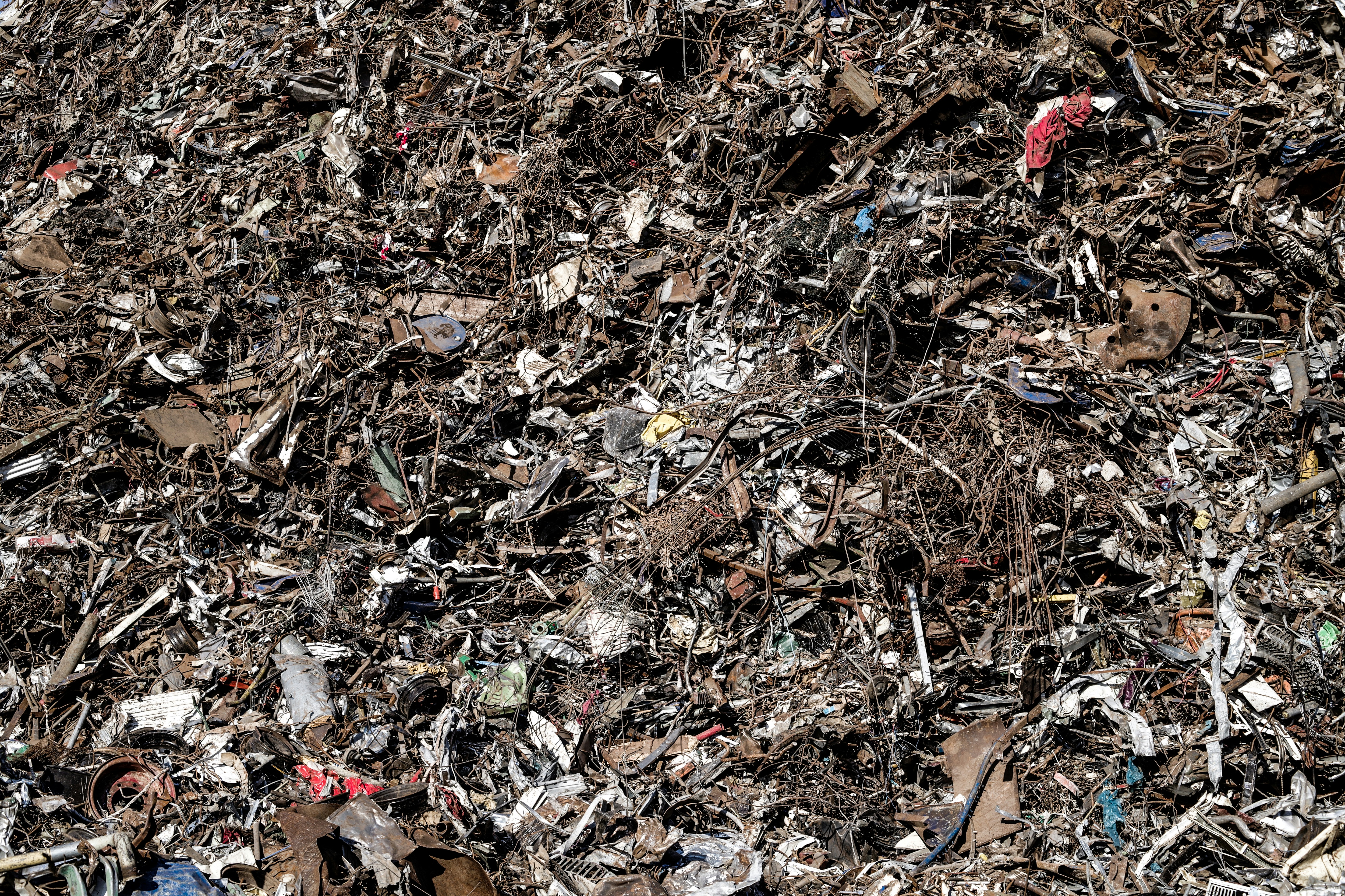 a pile of garbage with a red fire hydrant in the middle of it