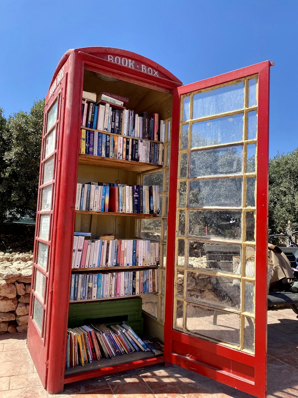a red phone booth with books inside of it