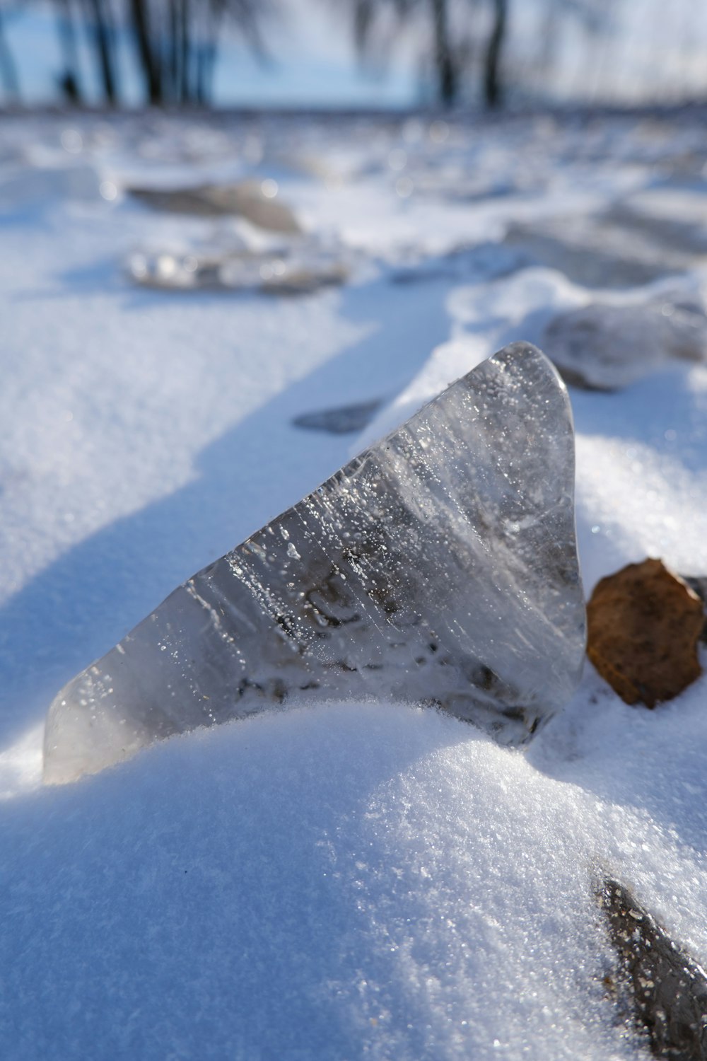 a piece of ice sitting on top of snow covered ground