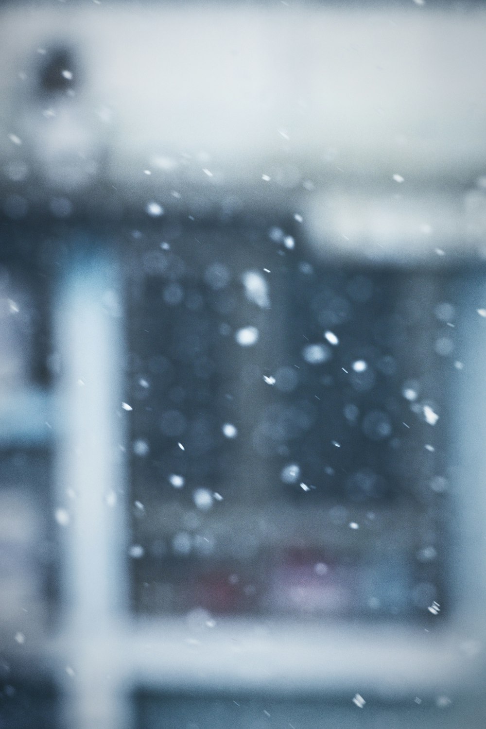 a blurry photo of a window with snow falling on it