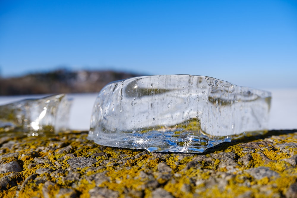 a broken glass bottle sitting on top of a rock