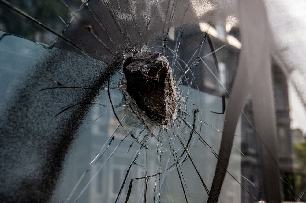 a shattered glass window with a building in the background