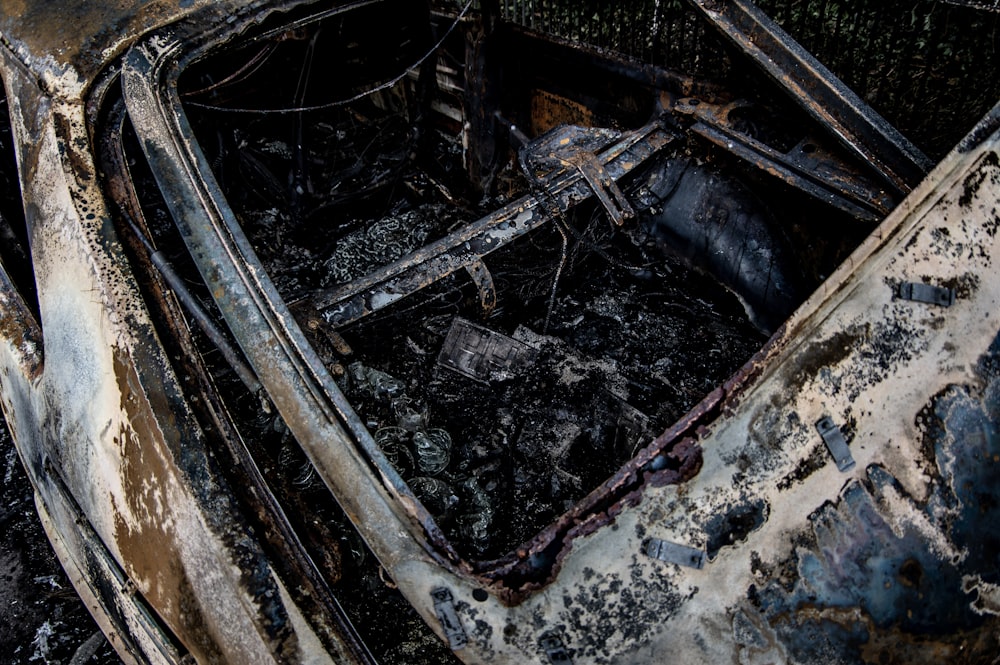a burned out car sitting in the middle of a field
