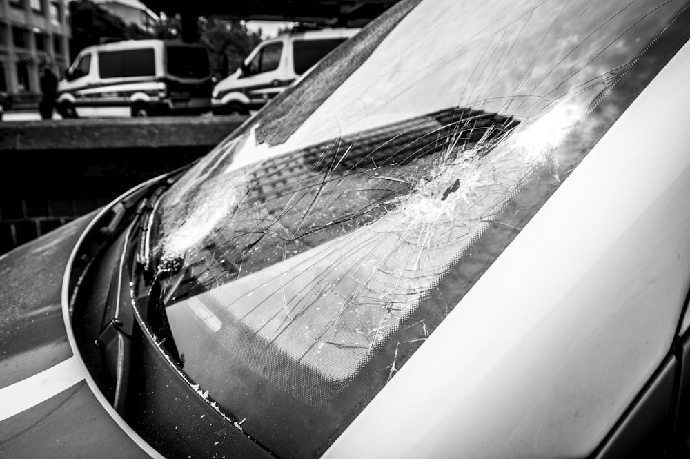 a broken windshield of a car on a city street