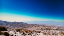 a view of a mountain range with a blue sky in the background