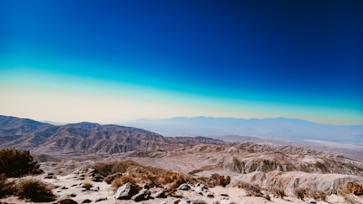 a view of a mountain range with a blue sky in the background
