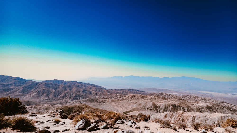 a view of a mountain range with a blue sky in the background