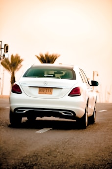 Luxurious black Mercedes S-Class driving along the sun-kissed coastline of the French Riviera at sunset.