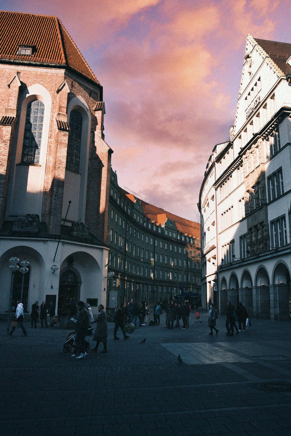 a group of people walking down a street next to tall buildings