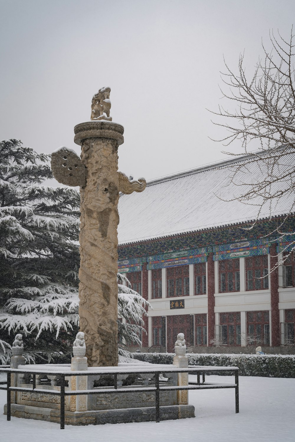 a snow covered park bench in front of a building