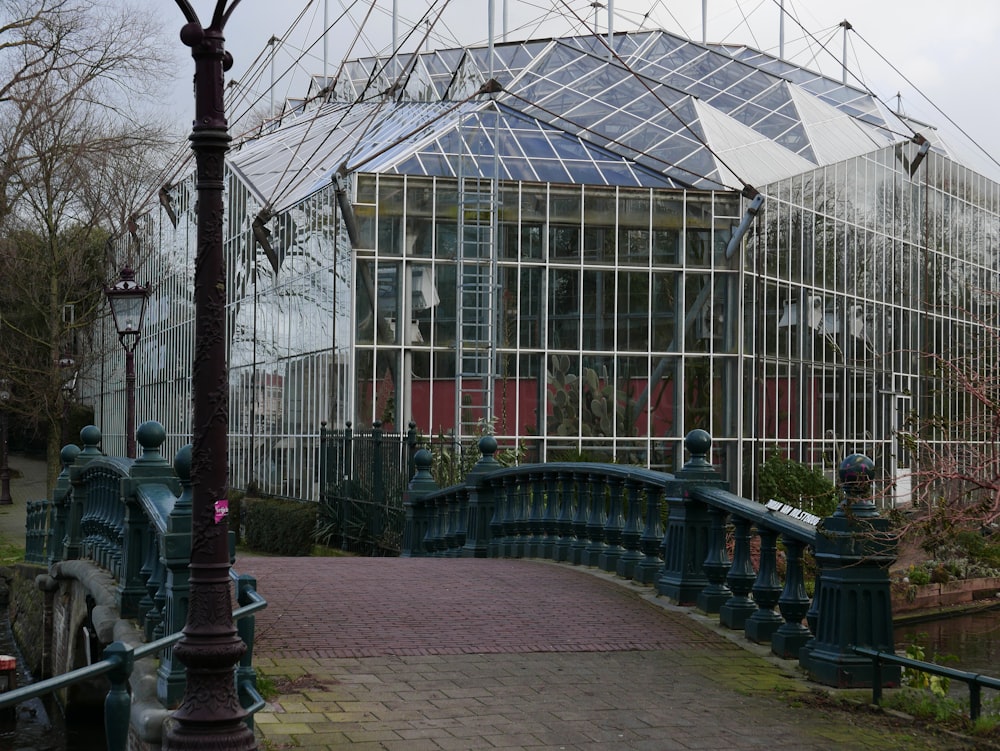 um edifício com um telhado de vidro ao lado de uma ponte