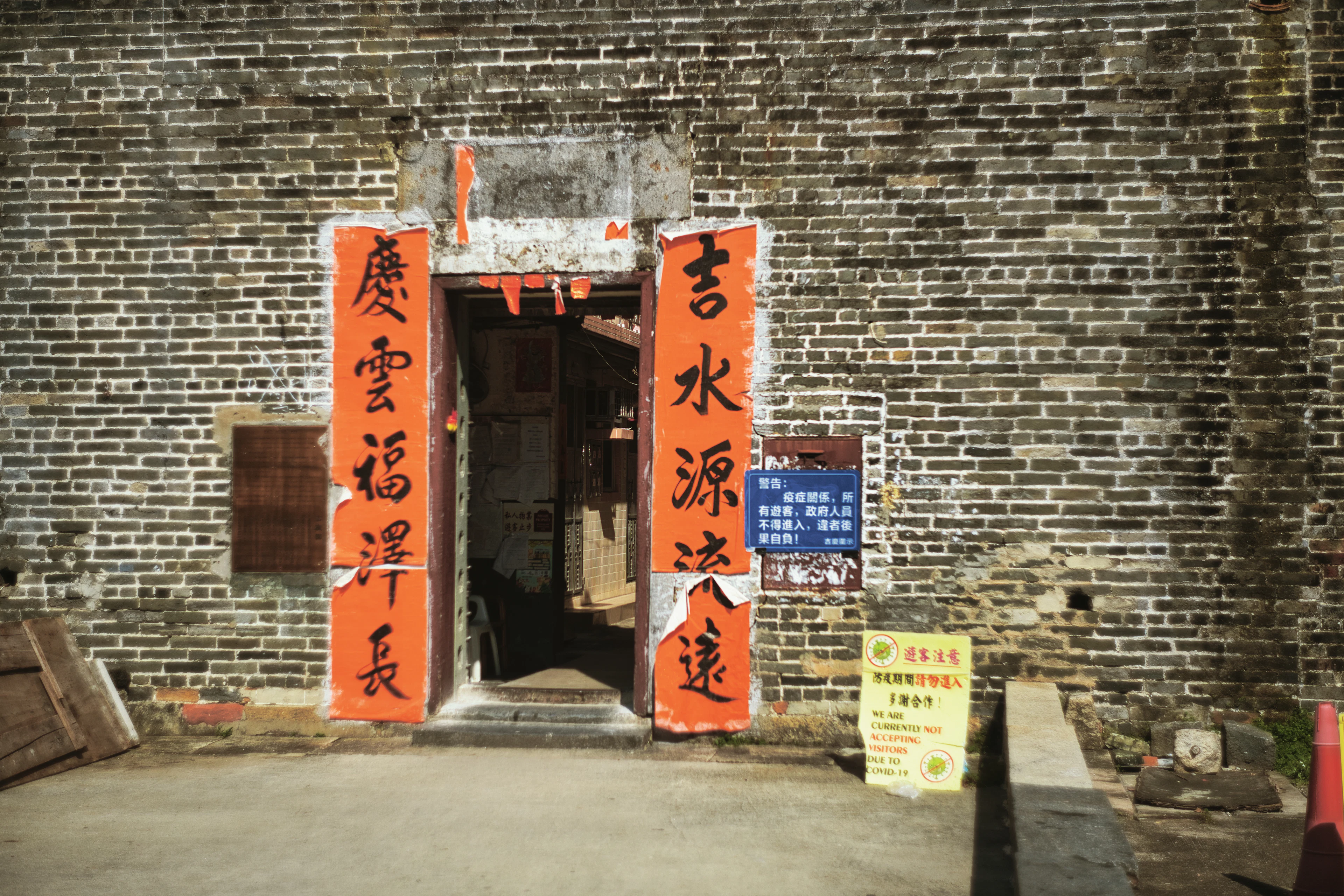 A brick gateway hung with red couplets in an old Hong Kong village