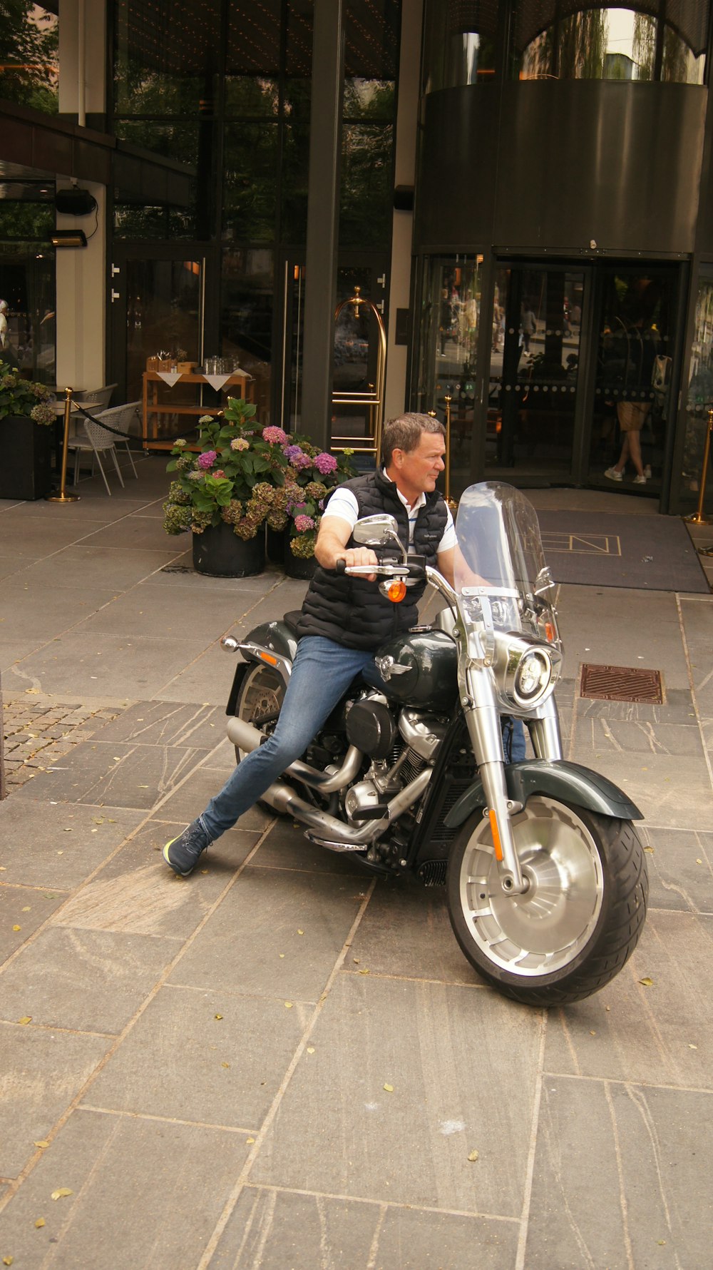 a man sitting on a motorcycle in front of a building