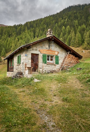 a small stone building with a green door and window