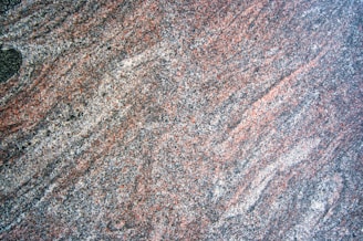 a close up of a granite surface with a black object in the middle